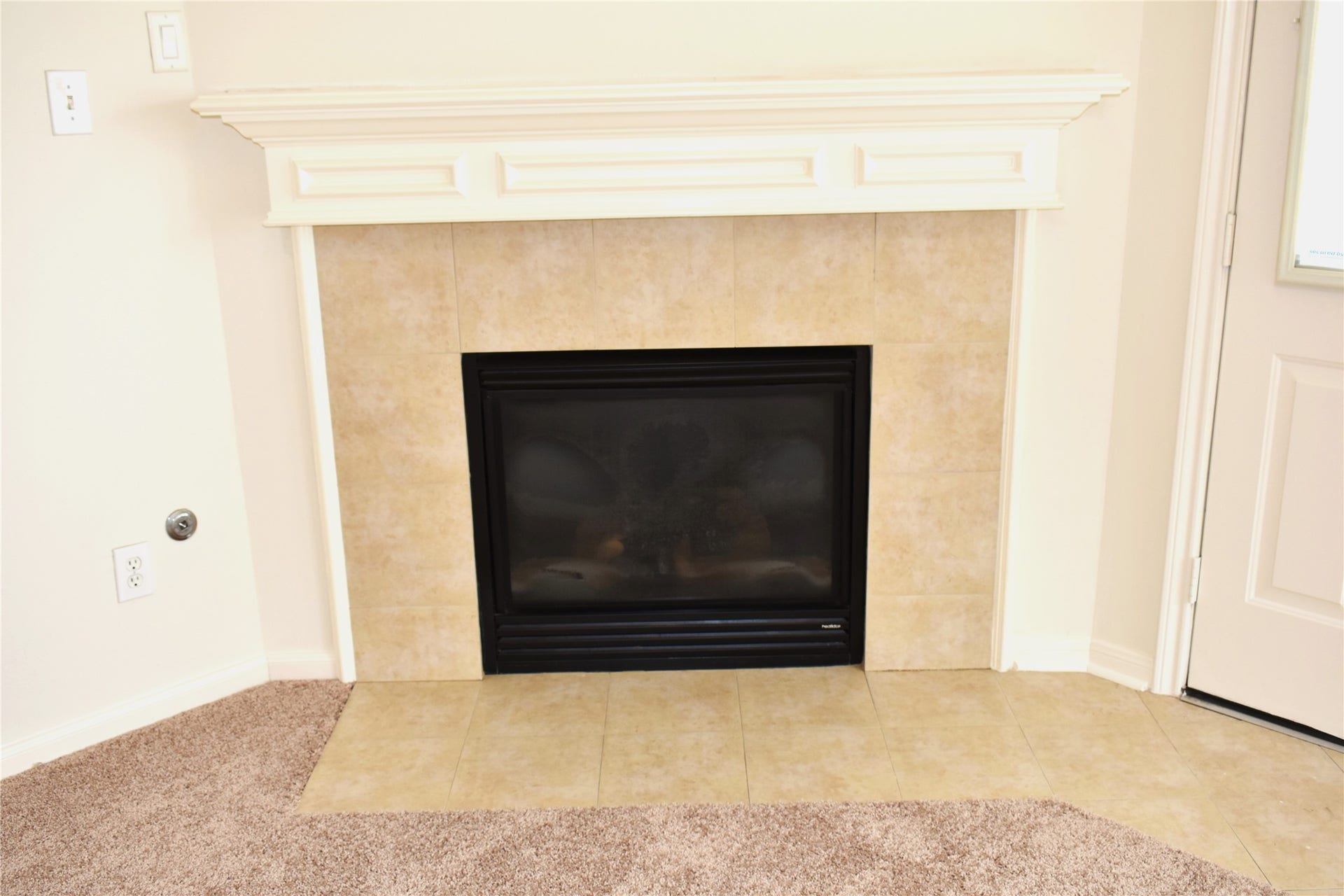 4822 Harbor Glen Lane, Houston, TX 77084 Cozy corner fireplace with elegant tile surround and a classic white mantel, perfect for adding warmth and charm to any room.