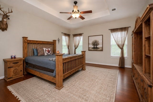 27644 Spring Hill Road, Hempstead, TX 77445 What a marvelous place for peace and repose! This primary suite invites super-sized pieces with amazing floor and wall space and bright, natural light. Note the tray ceiling theme, here too. This view has been AI enhanced to remove some of the furniture and add rug.