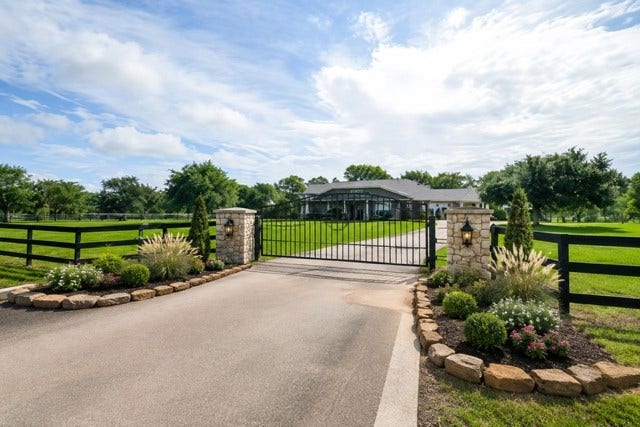 27644 Spring Hill Road, Hempstead, TX 77445 Grand gates. Beautiful grounds. Wide-open possibilities. This picturesque entry blends timeless country charm with polished landscaping, creating an inviting approach to this exceptional property. Landscape imaging is AI created.