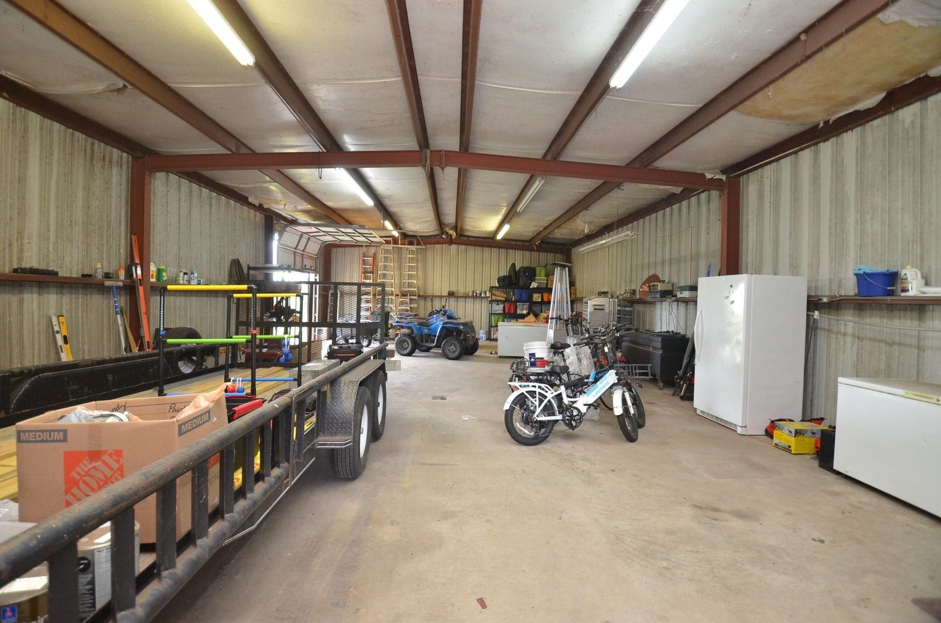 27644 Spring Hill Road, Hempstead, TX 77445 View of the inside of the shop with a roll up door in the back on the side