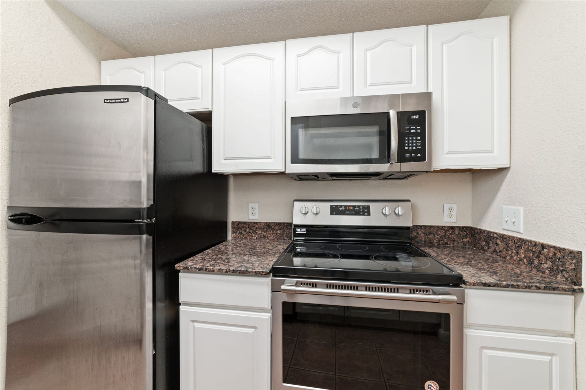 Modern kitchen design with granite countertops, stainless-steel appliances, and plenty of cabinet space. Fridge stays!