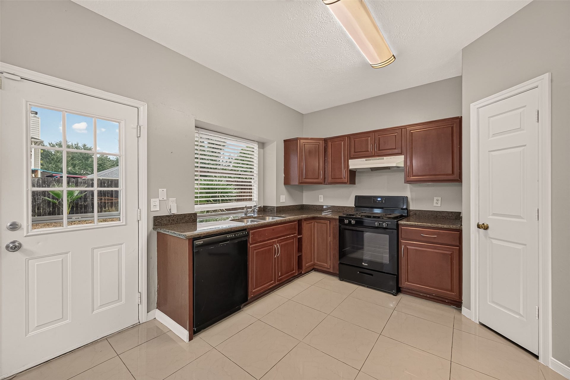22818 Williamschase Drive, Katy, TX 77449 Bright and inviting kitchen featuring rich wood cabinetry and dark countertops.