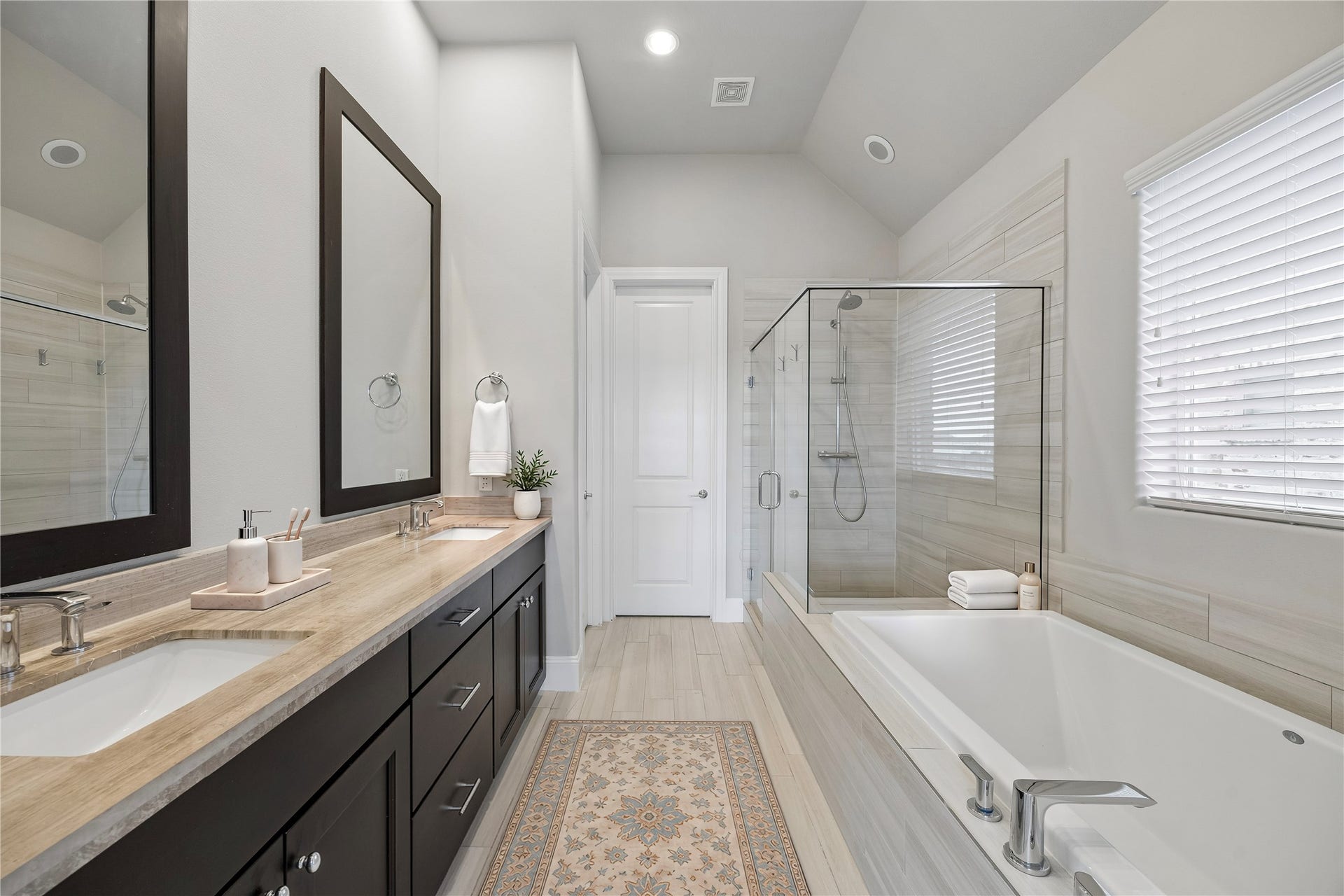 9664 Knight Road, Houston, TX 77045 The serene primary bathroom offers a long vanity with dual sinks, a walk-in glass shower and a soaking tub, perfect for relaxing after a long day.