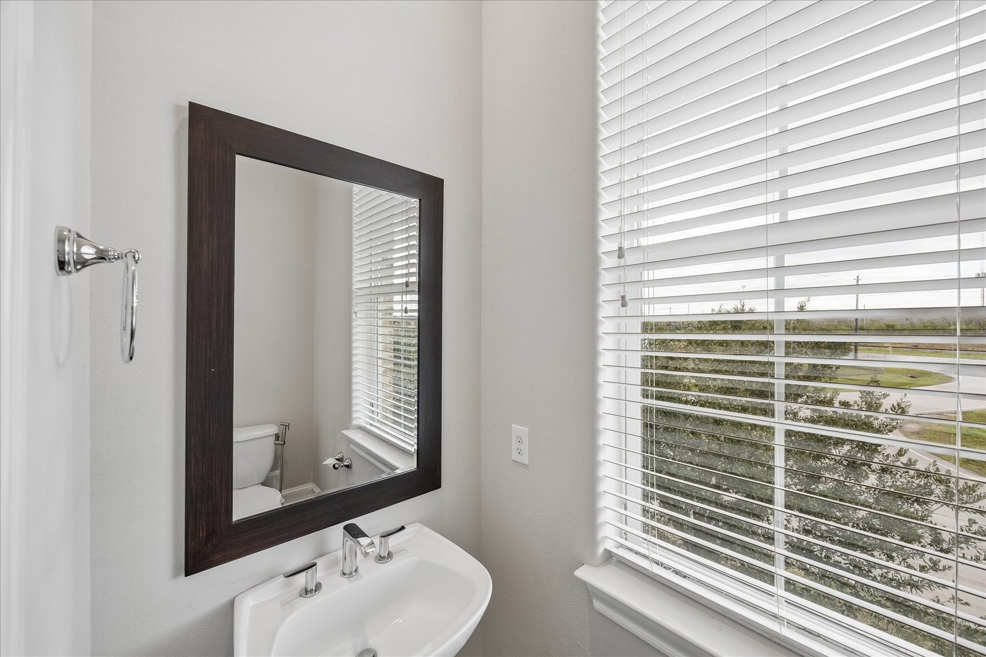 9664 Knight Road, Houston, TX 77045 A window brings natural light into the powder room, complete with a framed mirror and vanity.