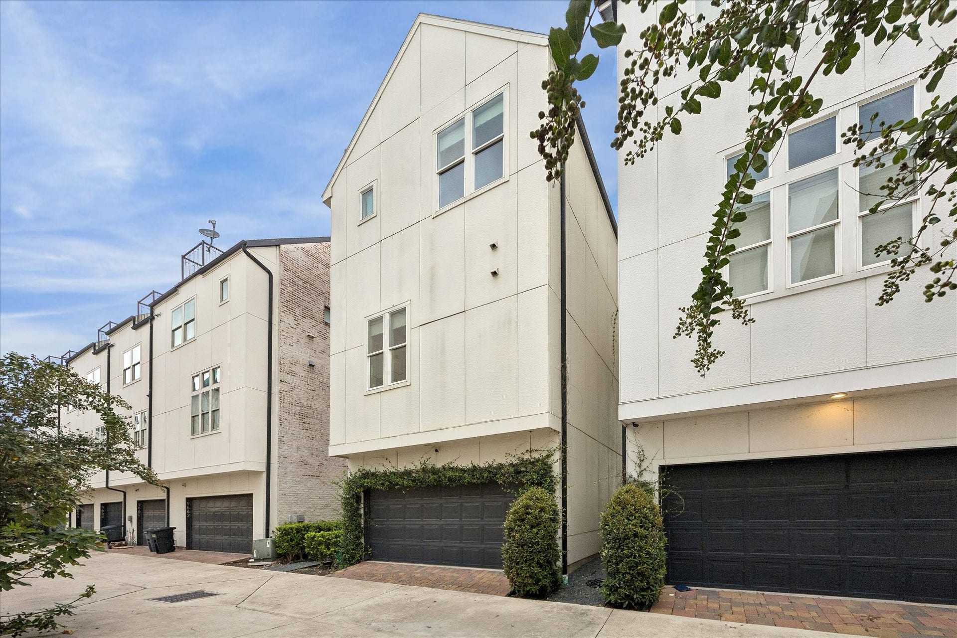 9664 Knight Road, Houston, TX 77045 This home has an attached, spacious 2-car garage, offering convenient parking and access. This exterior view highlights the homes central setting within the gated community, just steps from the beautiful community fountain.