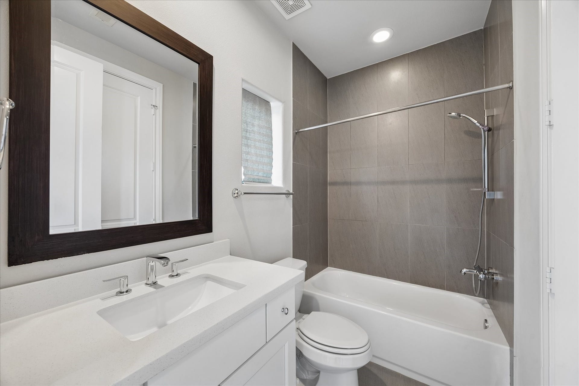 9664 Knight Road, Houston, TX 77045 This full bathroom includes a tiled tub-shower combo with an adjustable handheld showerhead.
