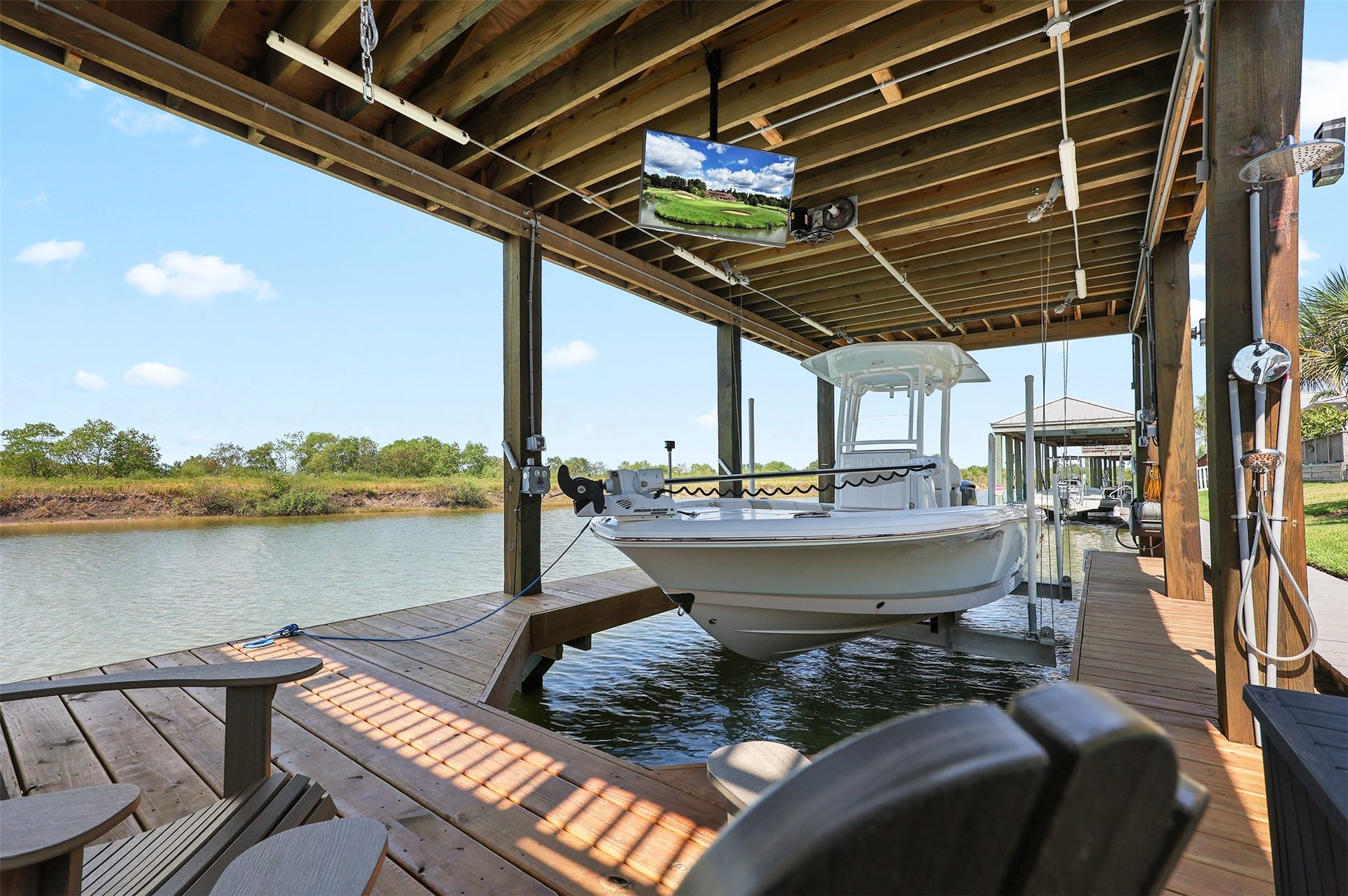 5418 Brigantine Cay Court, Texas City, TX 77590 36' Boathouse was installed in 2025. Notice the television and chairs for relaxing by the water.