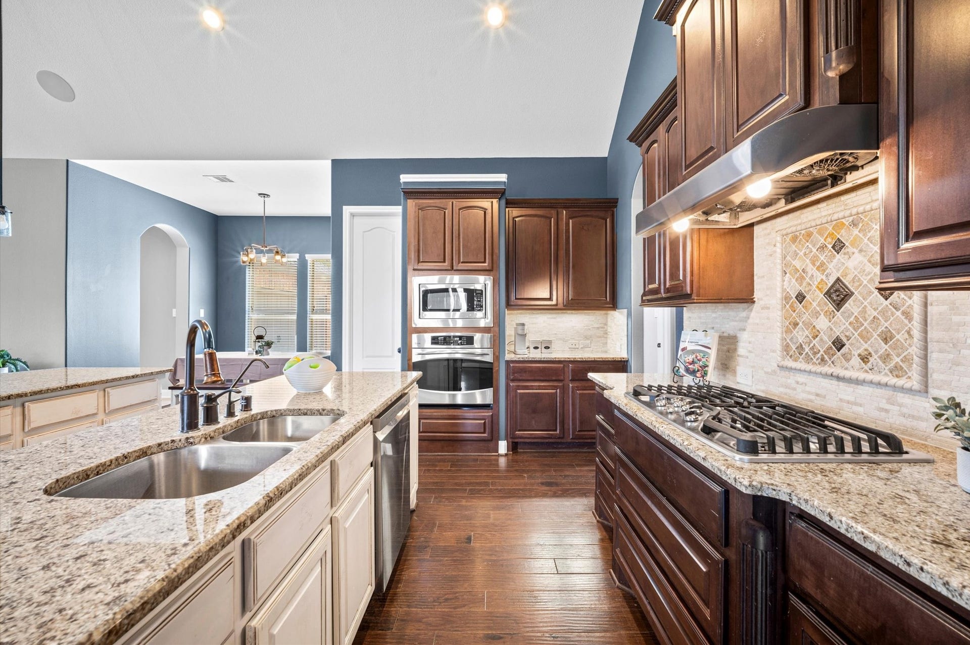 24611 Waterstone Estates Circle S, Tomball, TX 77375 Granite countertops blend beautifully with the rich wood cabinets. Enjoy a double sink and built-in dishwasher on the central island, as well as additional counter space and a breakfast bar on the outer island.