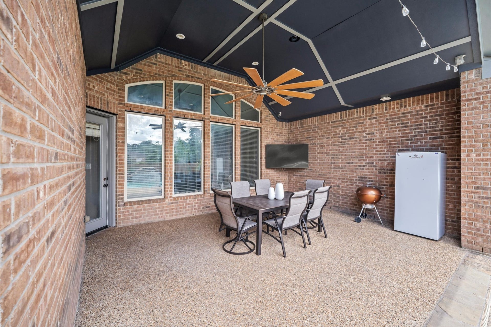 24611 Waterstone Estates Circle S, Tomball, TX 77375 A covered patio, complete with lights and a ceiling fan, is the perfect spot for outdoor chilling and grilling with a poolside view.