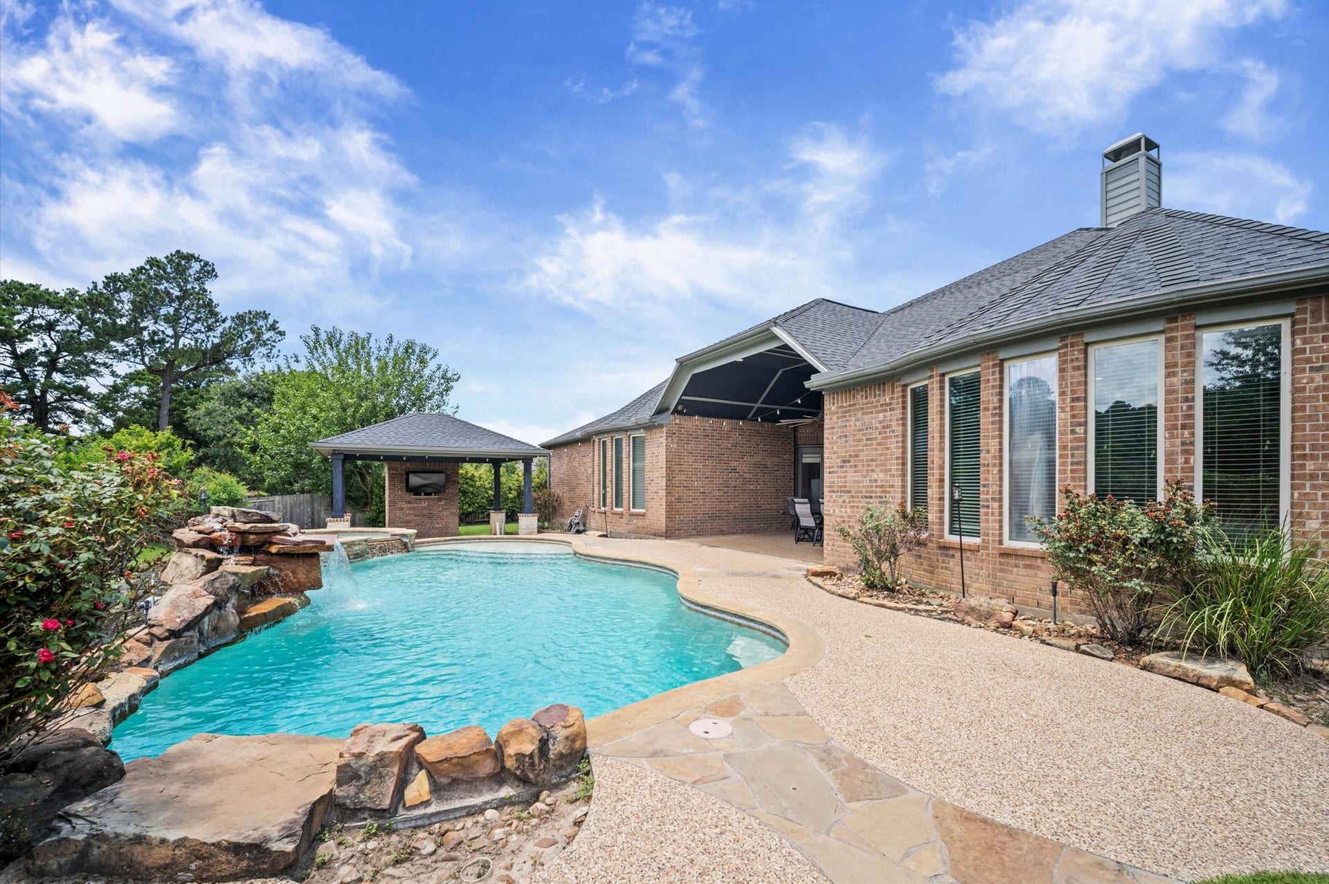 24611 Waterstone Estates Circle S, Tomball, TX 77375 Back to the luxurious backyard splendor! Your new backyard includes a gorgeous pool with a waterfall against a landscaped backdrop. On the far end is a hot tub, near the gazebo. The covered patio has a front row seat to the inviting pool.