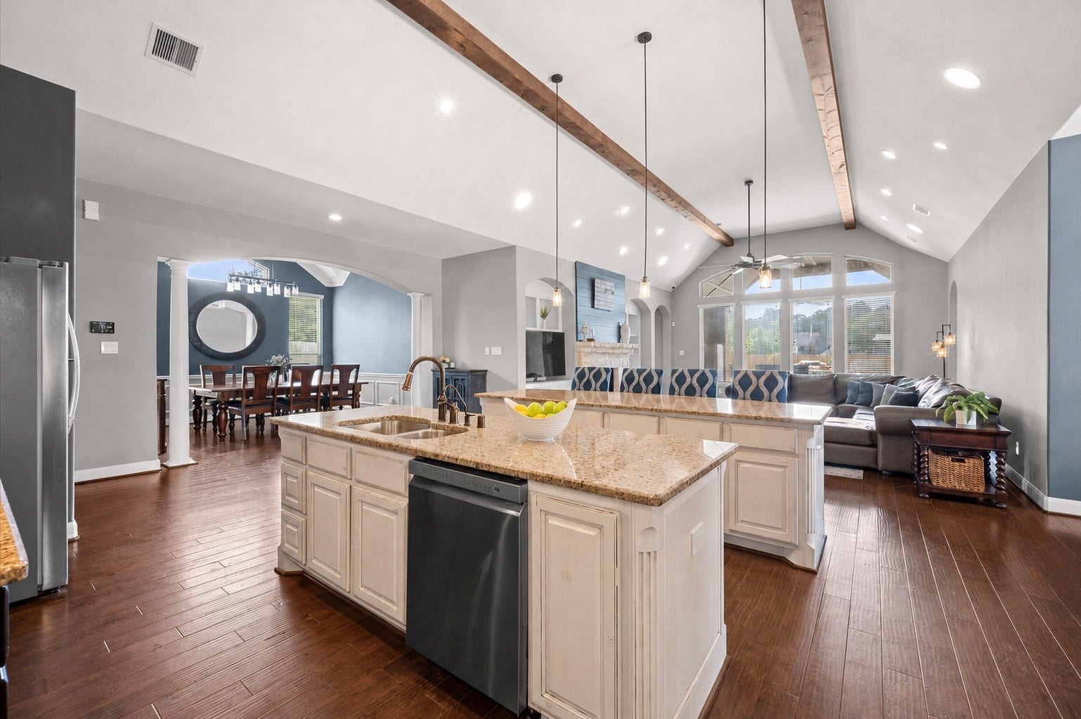 24611 Waterstone Estates Circle S, Tomball, TX 77375 From the kitchen, you have a nice view of the living room and dining room. The exposed beams are an artistic accent that joins these rooms together.