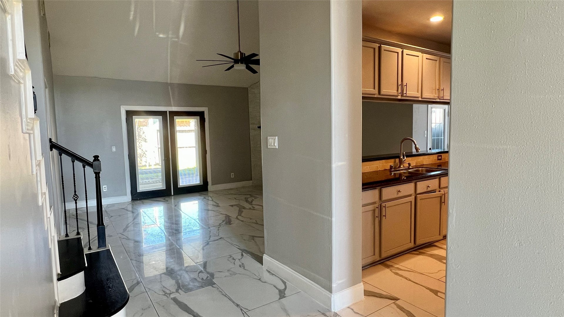This home features a bright, open living area with large high ceilings, and modern lighting.