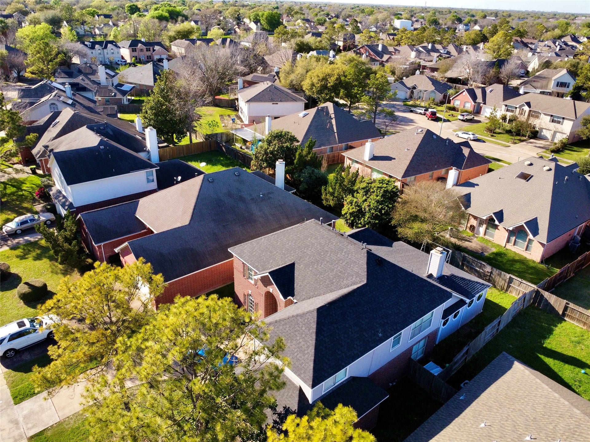 This aerial photo showcases a suburban neighborhood with spacious homes, neatly arranged on tree-lined streets. The houses have well-maintained yards, and the area appears peaceful and family-friendly, ideal for buyers seeking a community atmosphere.