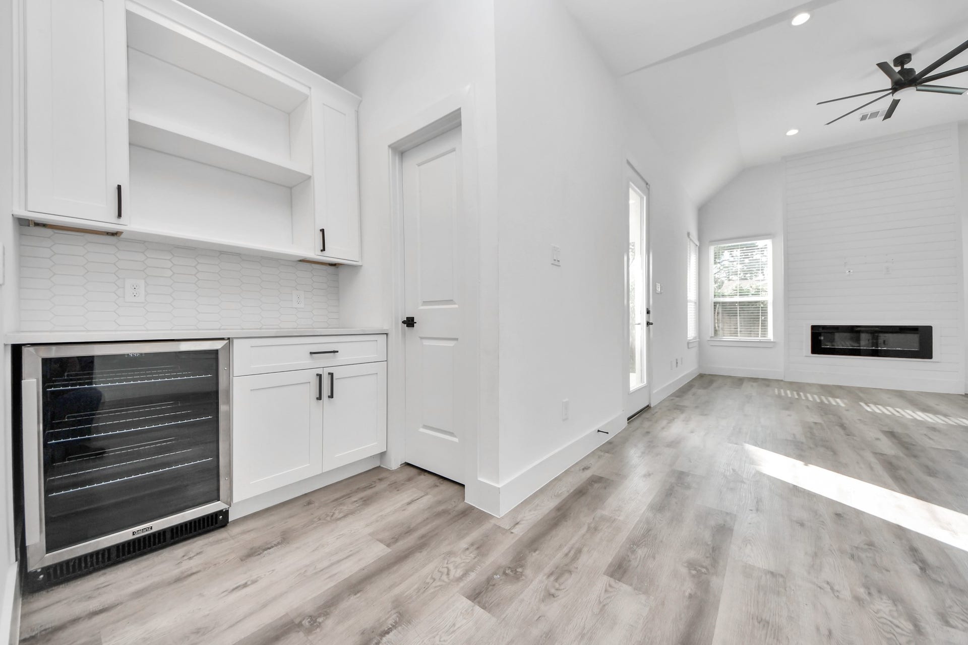 Built in dry bar with wine cooler, storage space, countertop space for appliances and open shelving for displaying decor.