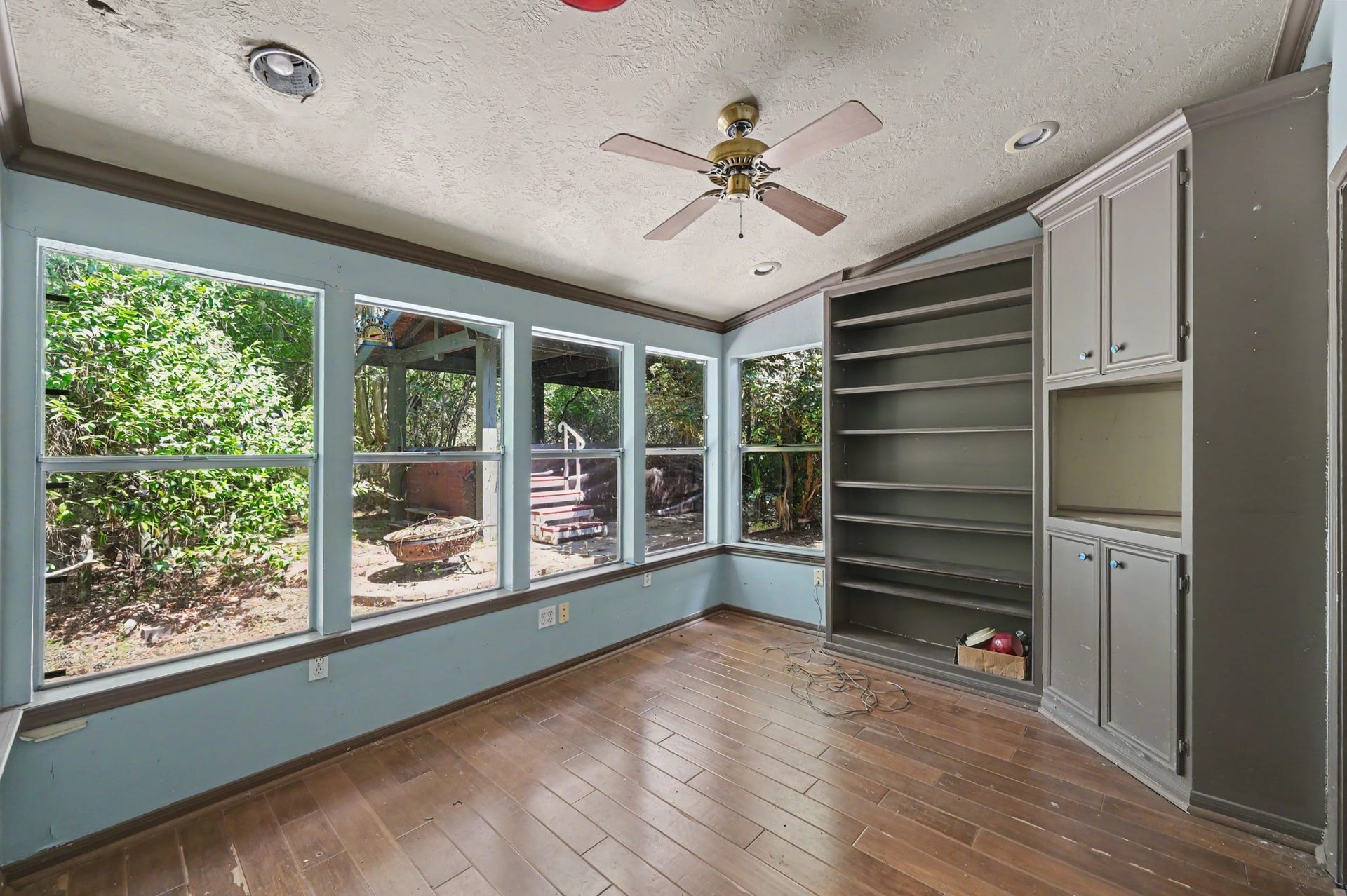 2710 N Logrun Circle, The Woodlands, TX 77380 A sunroom is off the multi-purpose space which you can access the backyard. There is a lot of space to display books along with great storage and a place to hook-up a TV.