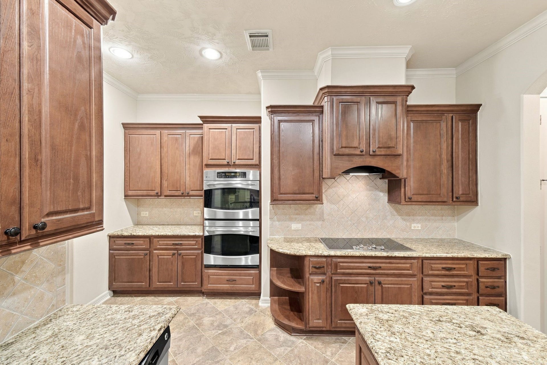 Kitchen has lots of cabinets and double oven.