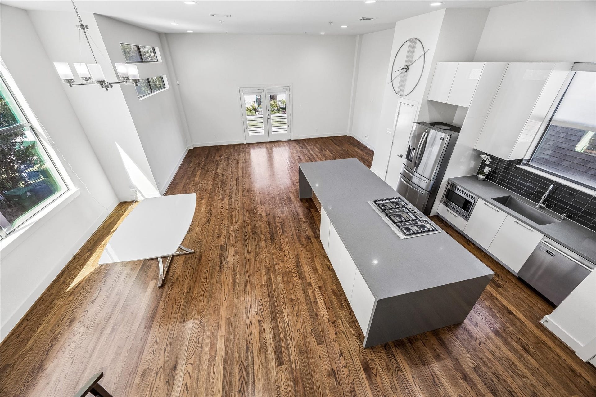 1215 Summer Street, #A, Houston, TX 77007 Elevated view showcasing the spacious main living level, with an open kitchen, dining area, and living space. Large windows and balcony doors bring natural light into the interior.