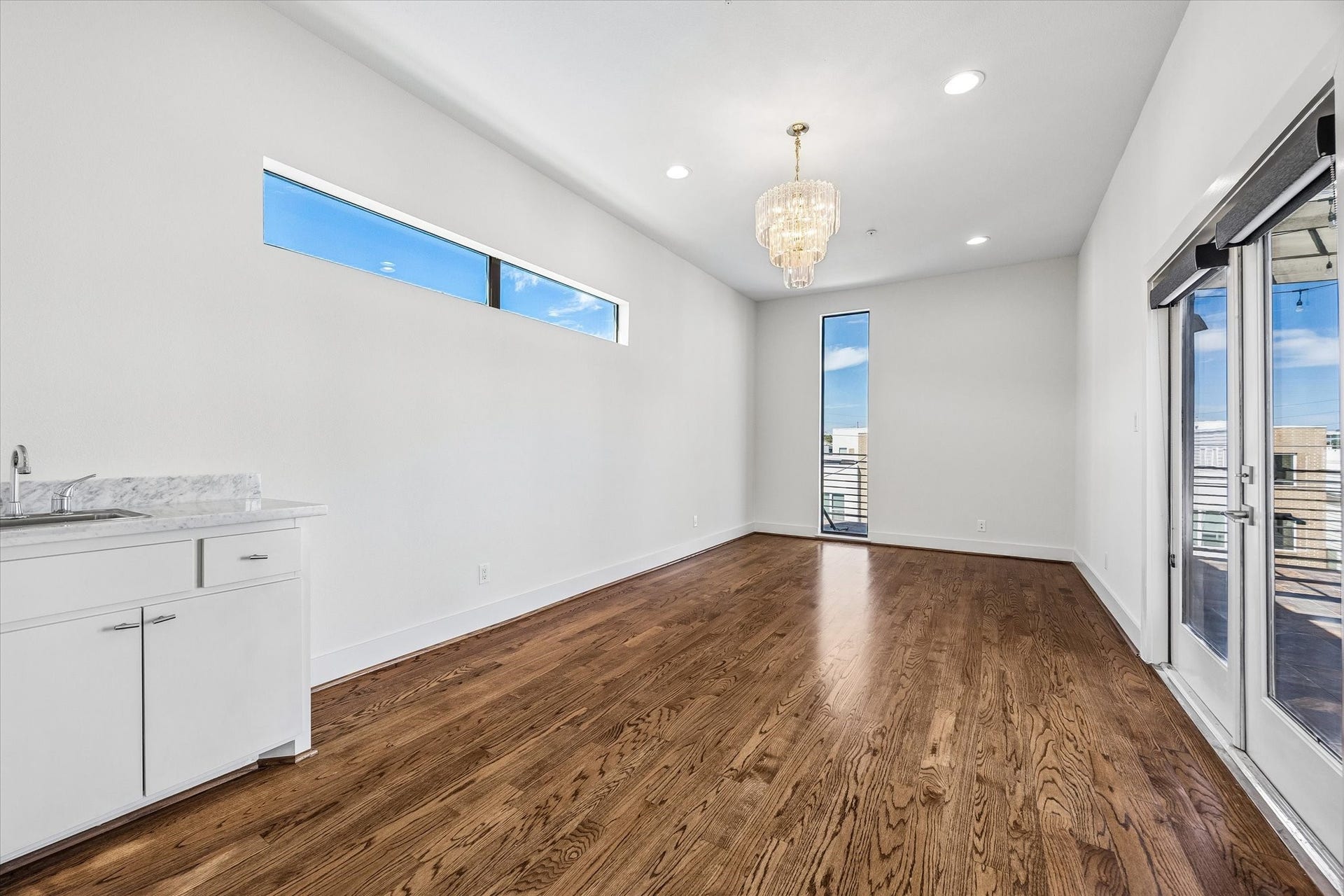 1215 Summer Street, #A, Houston, TX 77007 Upper-level flex space with wood flooring, clerestory windows, and a built-in wet bar. French doors connect the room directly to the rooftop terrace.