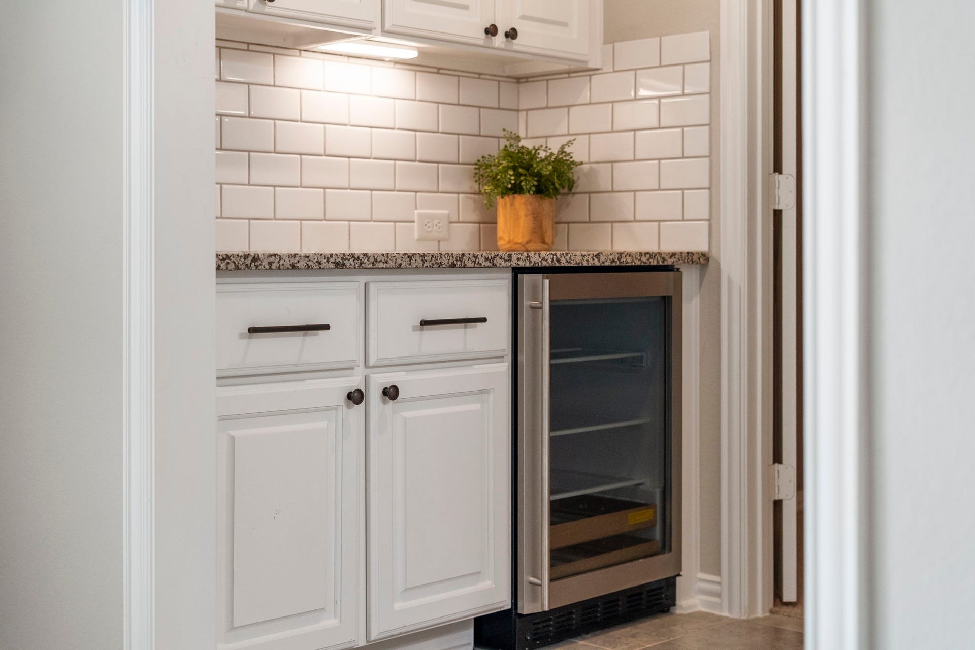 9410 Mount Logan, Missouri City, TX 77459 The upstairs refreshment center is thoughtfully appointed with granite countertops, a timeless subway tile backsplash, custom cabinetry, and a built-in beverage refrigerator for added convenience.