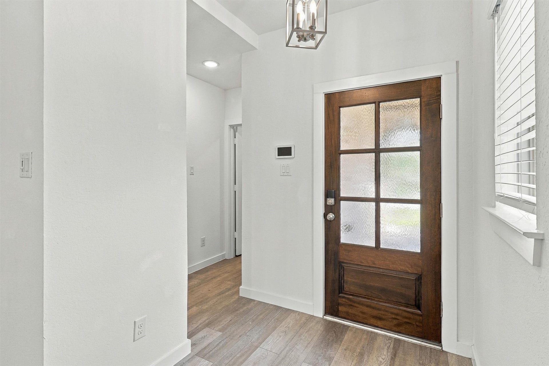 13109 Blue Flora Drive, Texas City, TX 77568 Entry way with custom pendant light and beautiful window. Directly to the Left, find the laundry room and garage entry.