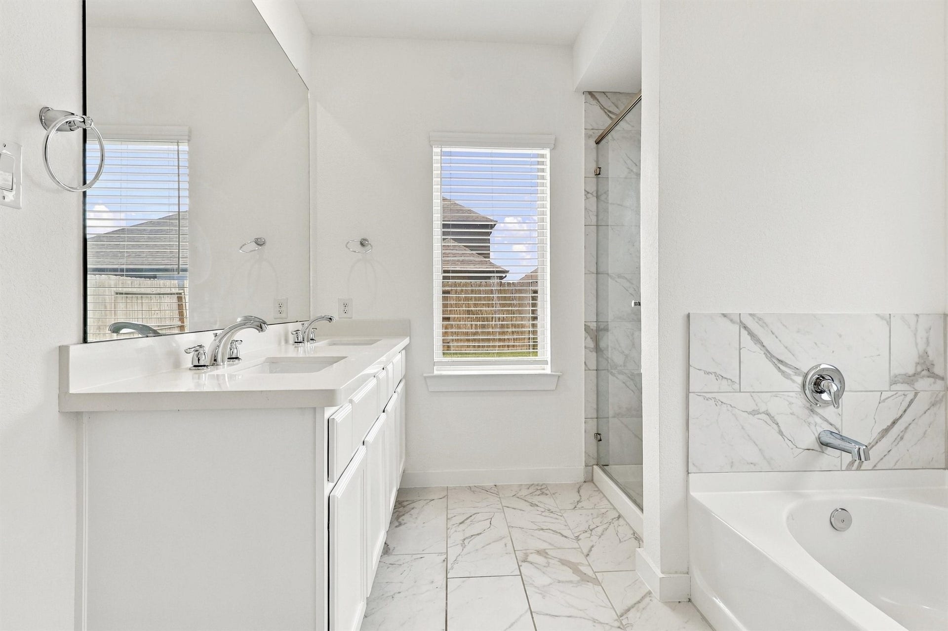 13109 Blue Flora Drive, Texas City, TX 77568 This gorgeous primary bath features double sinks, tile and glass shower, solid surface countertops, undermount sinks, separate soaking tub, and lots of natural light.