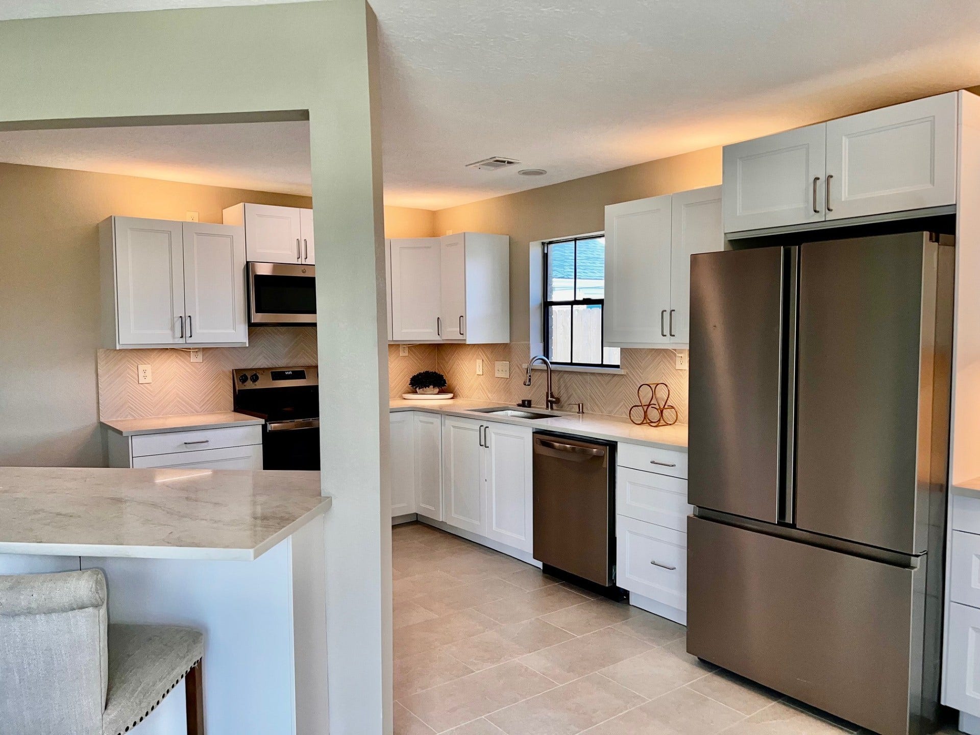 An island breakfast bar and indirect accent lighting add so much character to this space!