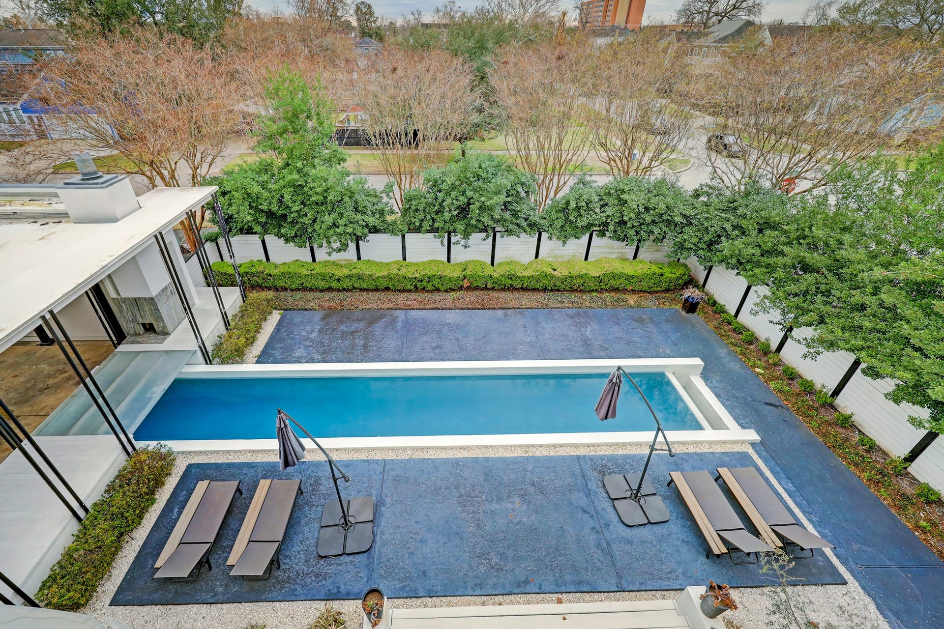 2200 Harvard Street, Houston, TX 77008 The tree-lined fence adds privacy for the chic, large rectangle spillover pool beyond, that will leave your guests in awe.