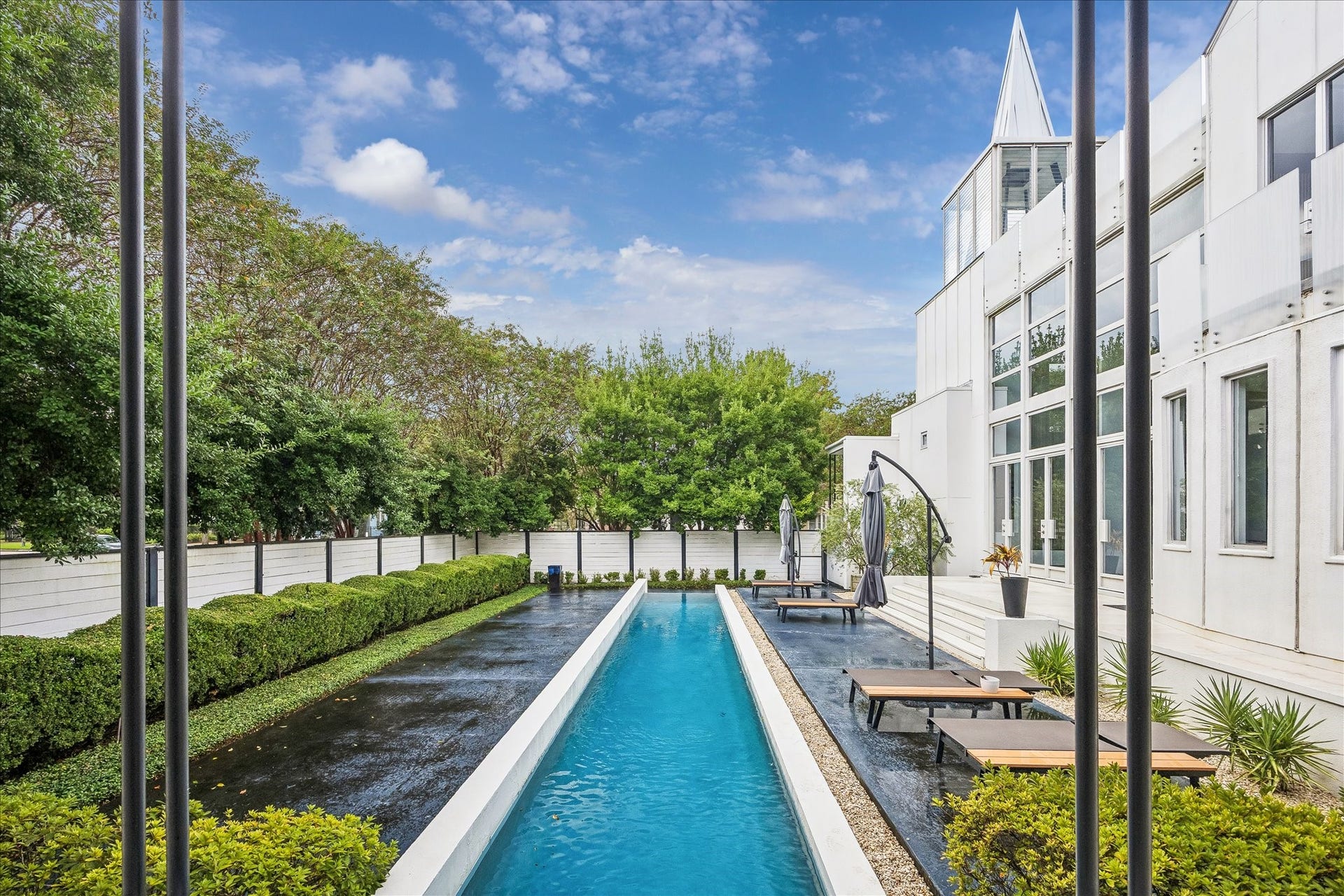 2200 Harvard Street, Houston, TX 77008 This view captures the pool alongside the homes soaring windows and signature steeple, bringing its distinctive architecture and outdoor setting together.