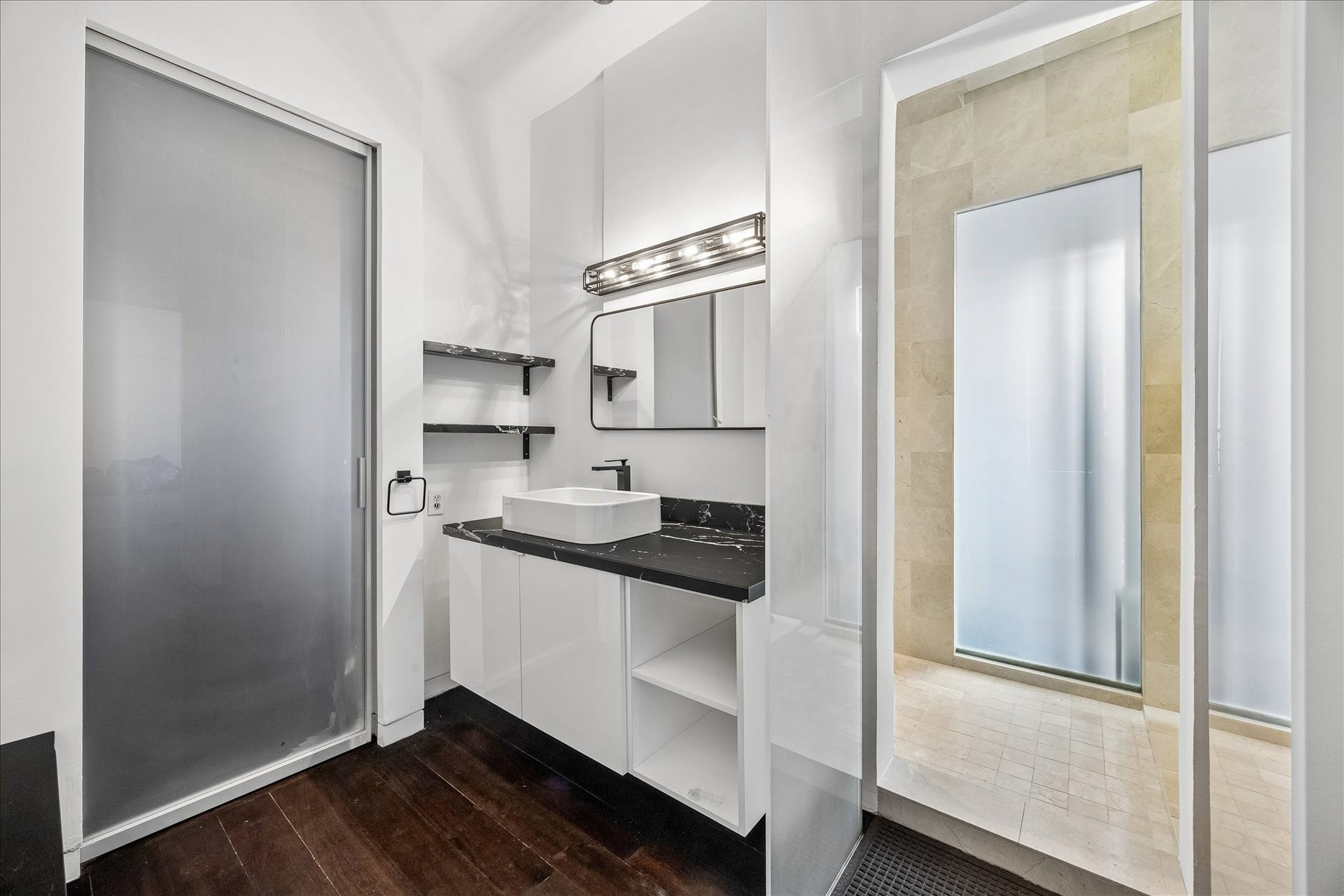 2200 Harvard Street, Houston, TX 77008 A sleek Jack-and-Jill bath connects the two downstairs bedrooms, featuring a floating vanity, vessel sink, stone countertop, and clean contemporary finishes.