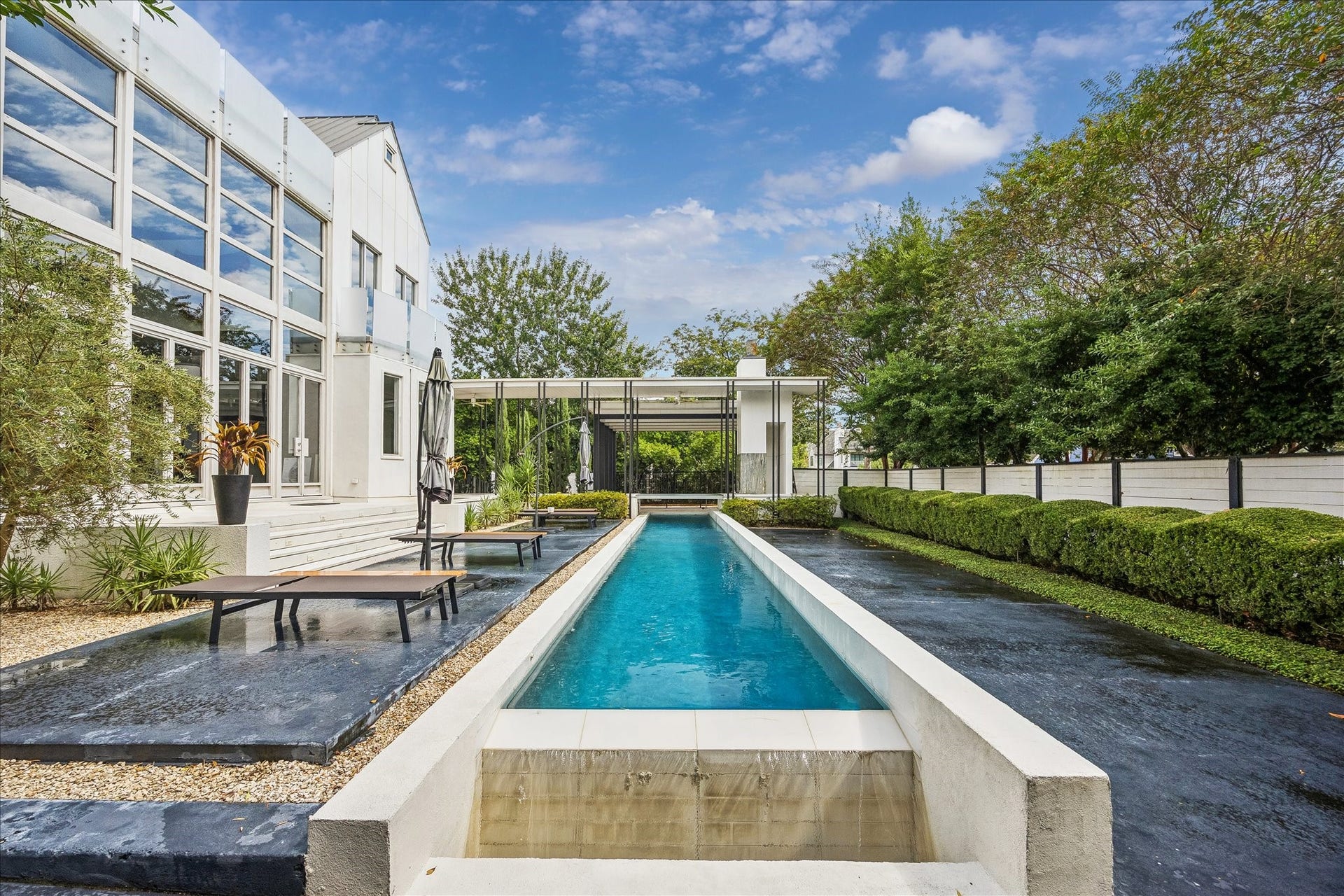 2200 Harvard Street, Houston, TX 77008 From this perspective, the pool becomes a striking architectural axis, drawing the eye toward the covered parking structure and anchoring the expansive backyard.