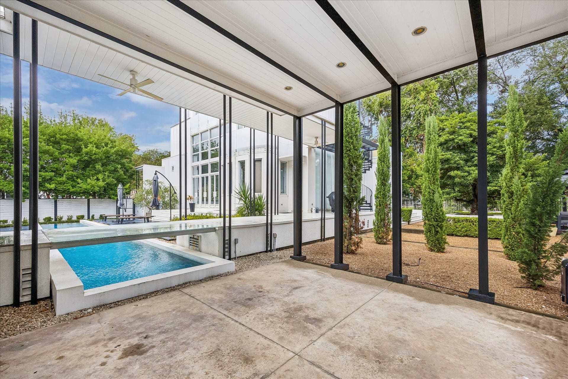 2200 Harvard Street, Houston, TX 77008 Covered parking blends seamlessly into the homes architectural design, while the open structure preserves views across the pool and landscaped grounds.