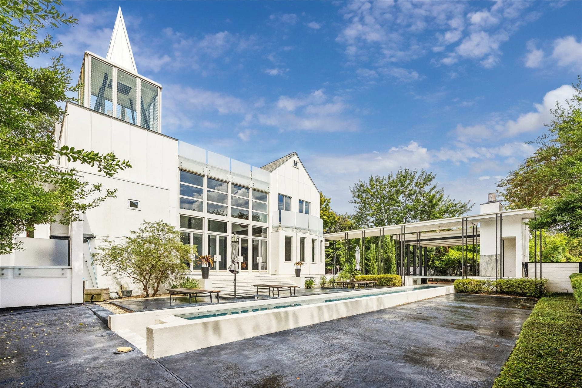 2200 Harvard Street, Houston, TX 77008 A sweeping backyard view showcases the pool, expansive lounge and entertaining areas, and the homes dramatic architecture, crowned by its signature steeple.