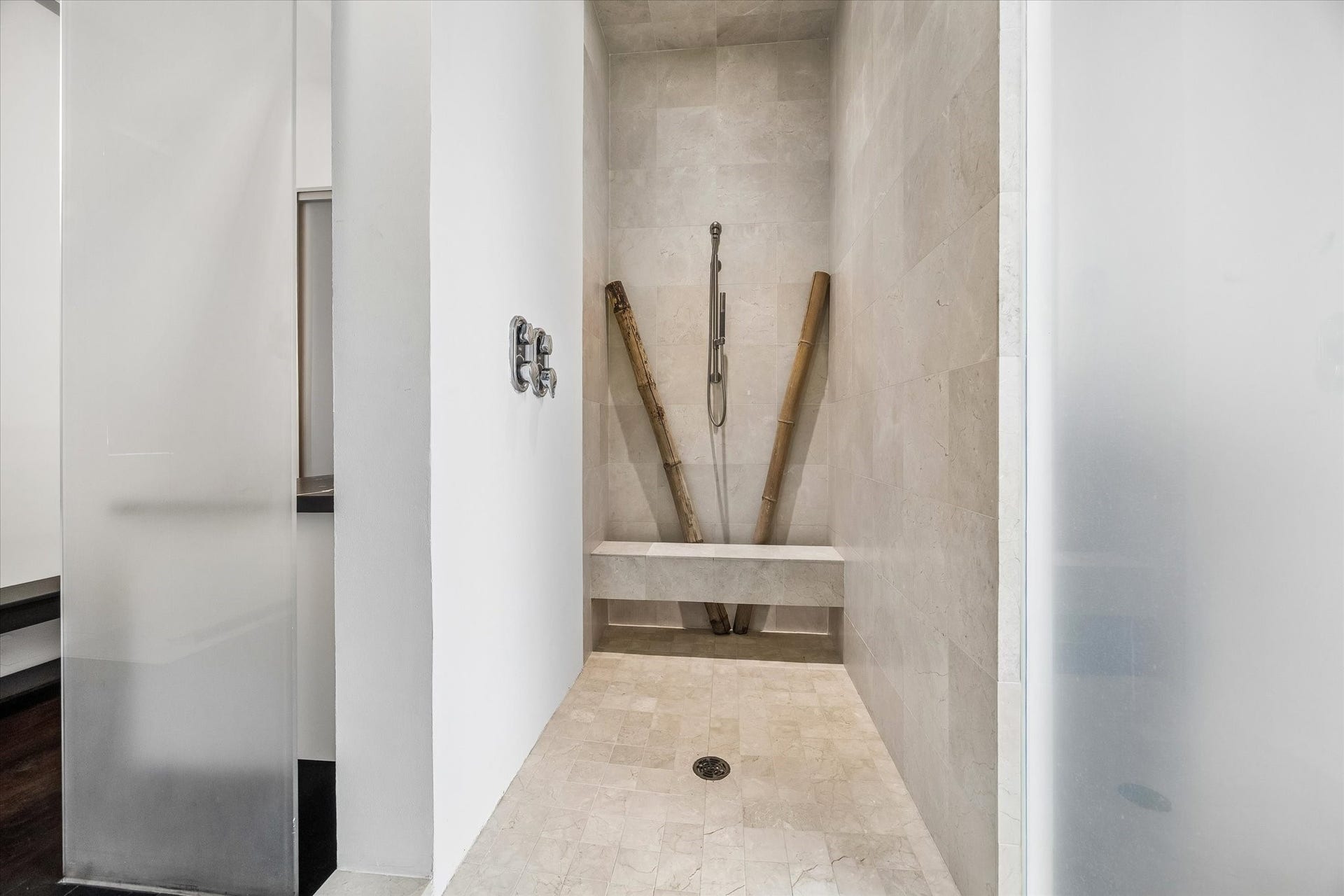 2200 Harvard Street, Houston, TX 77008 Directly across from the soaking tub, an oversized walk-in shower is finished in warm stone with a built-in bench, creating a spa-like complement to the bath.