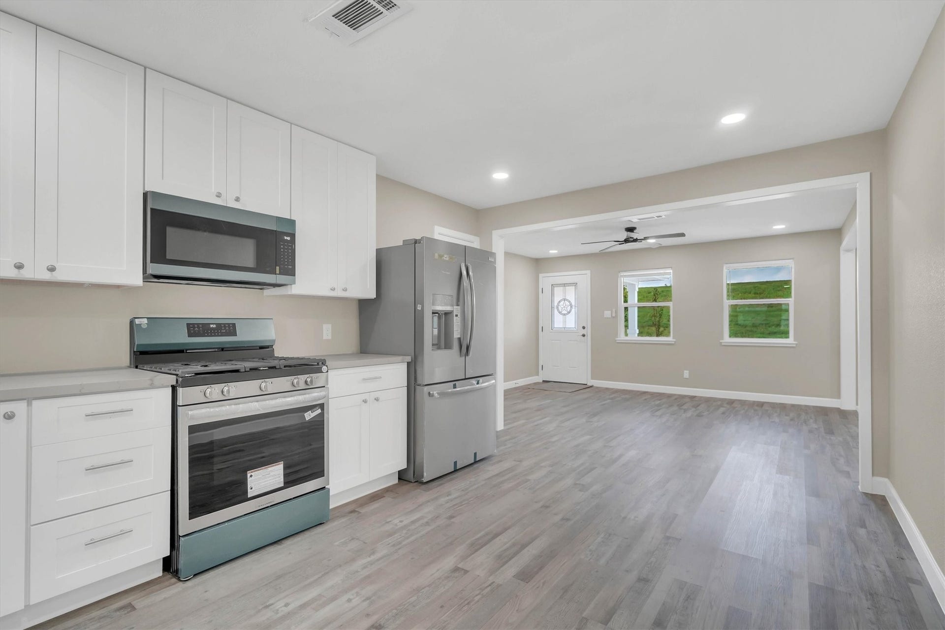 Kitchen and living area adorned with elegant flooring, creating a bright and inviting space.