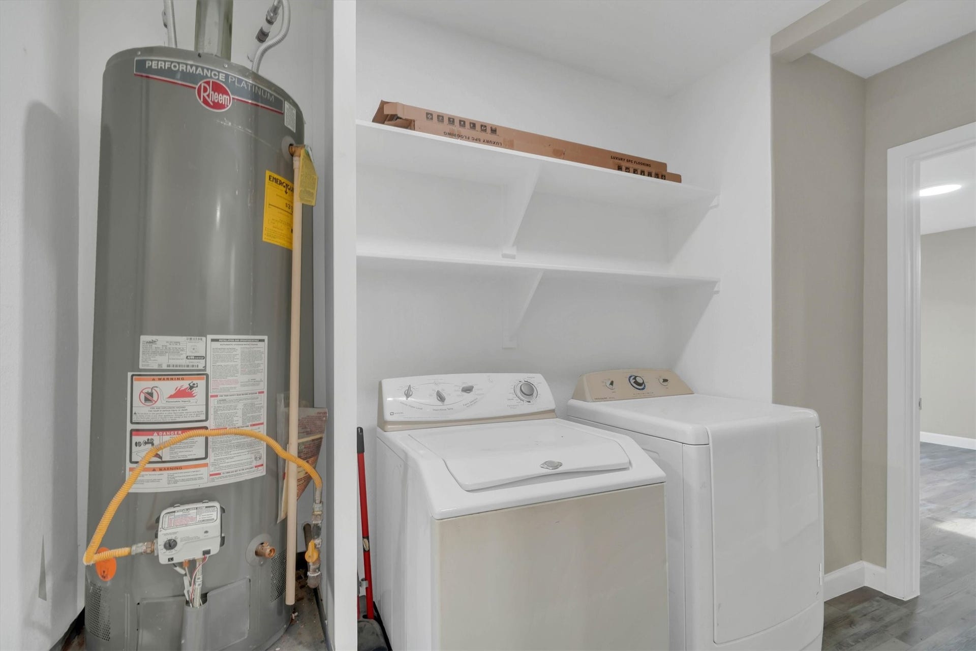 Convenient  indoor laundry area with washer, dryer, and shelving for plenty of storage