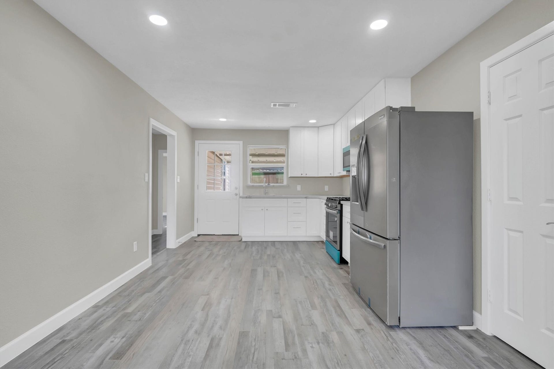 Modern kitchen featuring sleek stainless steel appliances, elegant cabinetry, and light color flooring, creating a bright and inviting space.