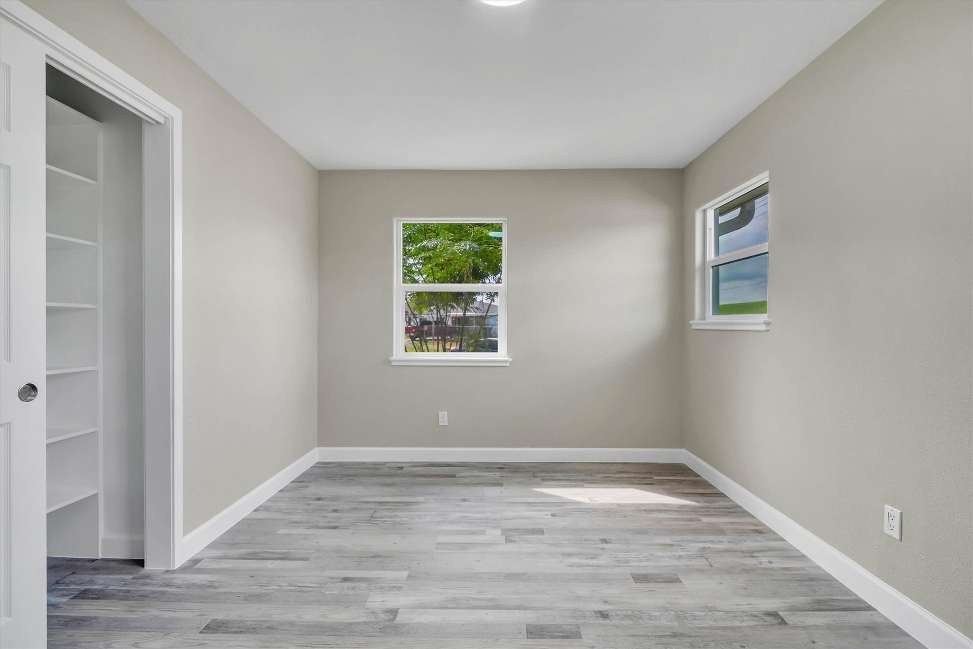 This bedroom contains an abundance of natural light from dual windows, perfect for a cozy retreat or home office.