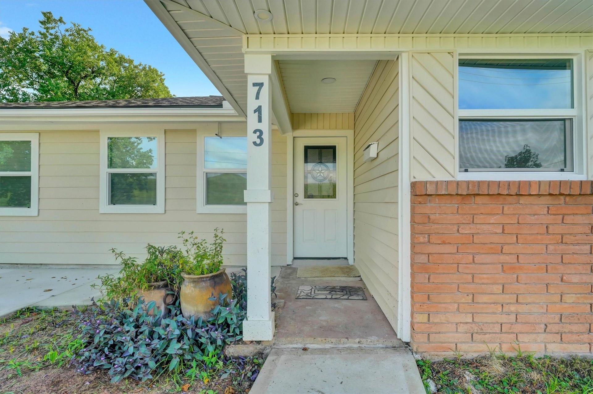 Entryway with a welcoming front door & tasteful brick accents.