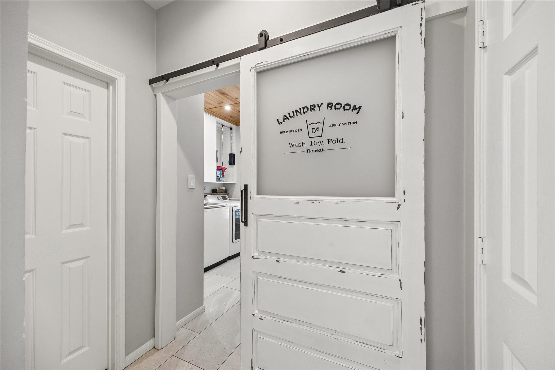 15106 Chestnut Glen Lane, Cypress, TX 77429 Even the practical spaces have a little personality. A rustic sliding barn door opens to the laundry room, adding a charming architectural detail to an everyday part of the home.