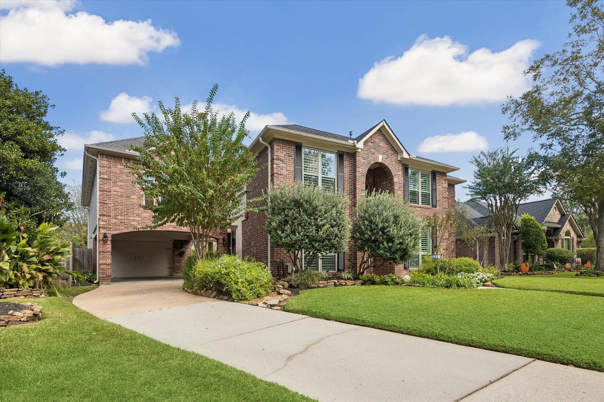 15106 Chestnut Glen Lane, Cypress, TX 77429 A convenient porte cochere provides covered access and leads toward the garage, combining practical everyday function with the home's traditional architecture.