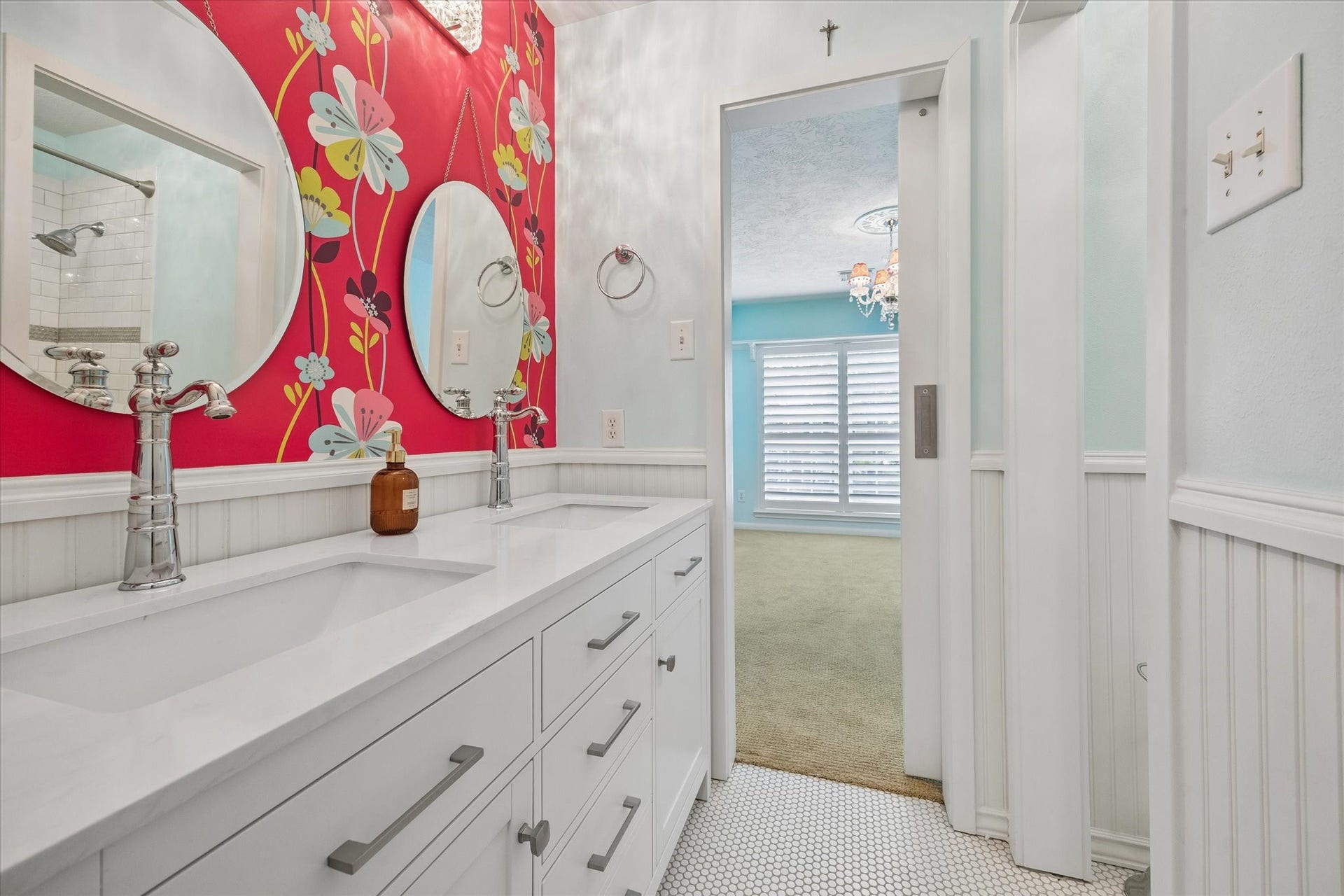 15106 Chestnut Glen Lane, Cypress, TX 77429 This beautifully updated bathroom combines a spacious dual-sink vanity, fresh white cabinetry, and playful accent wallpaper, creating a bright, inviting space that makes everyday routines feel a little more enjoyable.