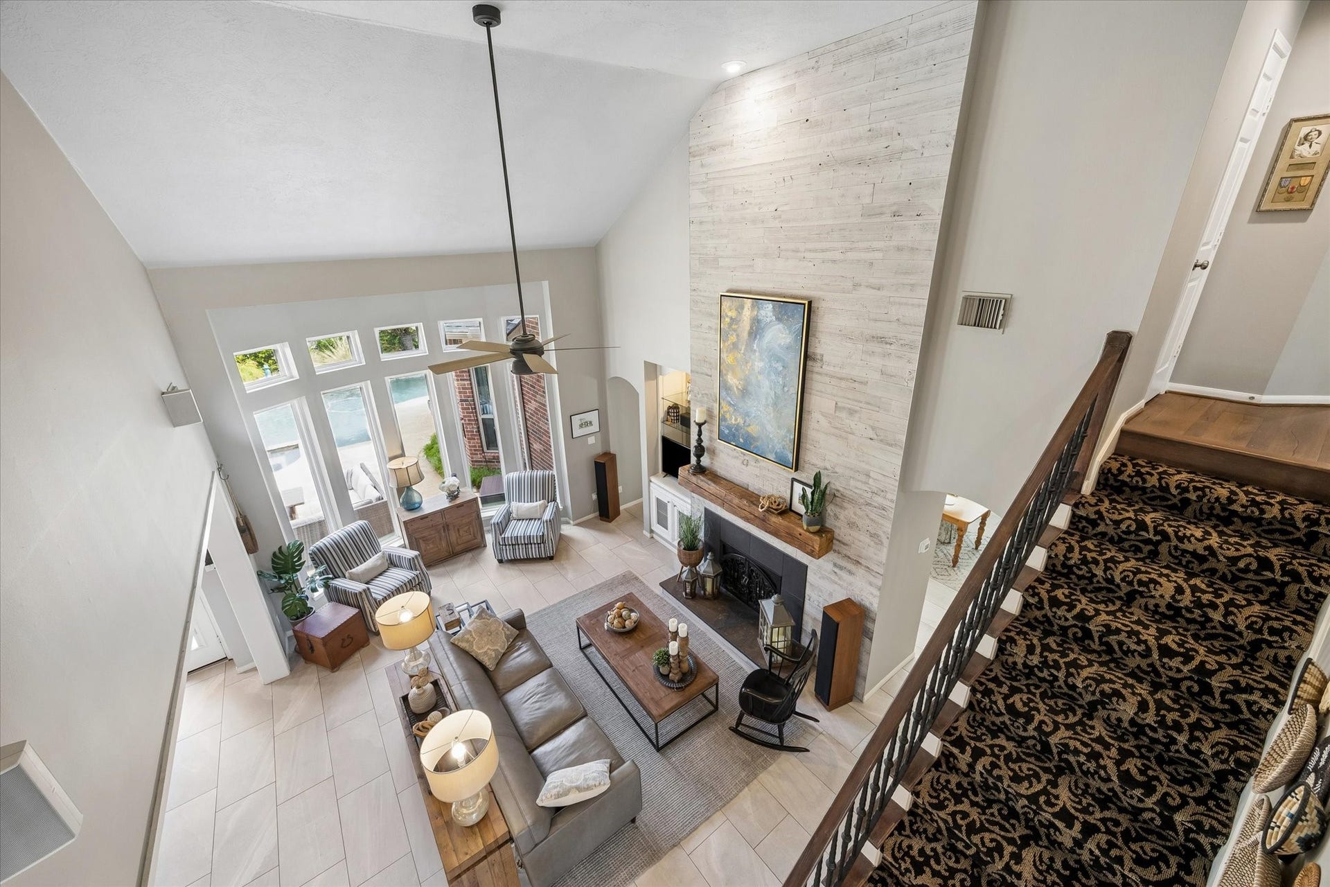 15106 Chestnut Glen Lane, Cypress, TX 77429 Looking down from the upstairs landing, the impressive ceiling heights and open architectural design become even more apparent. This beautiful perspective highlights the home's spacious feel and connection between the living areas.