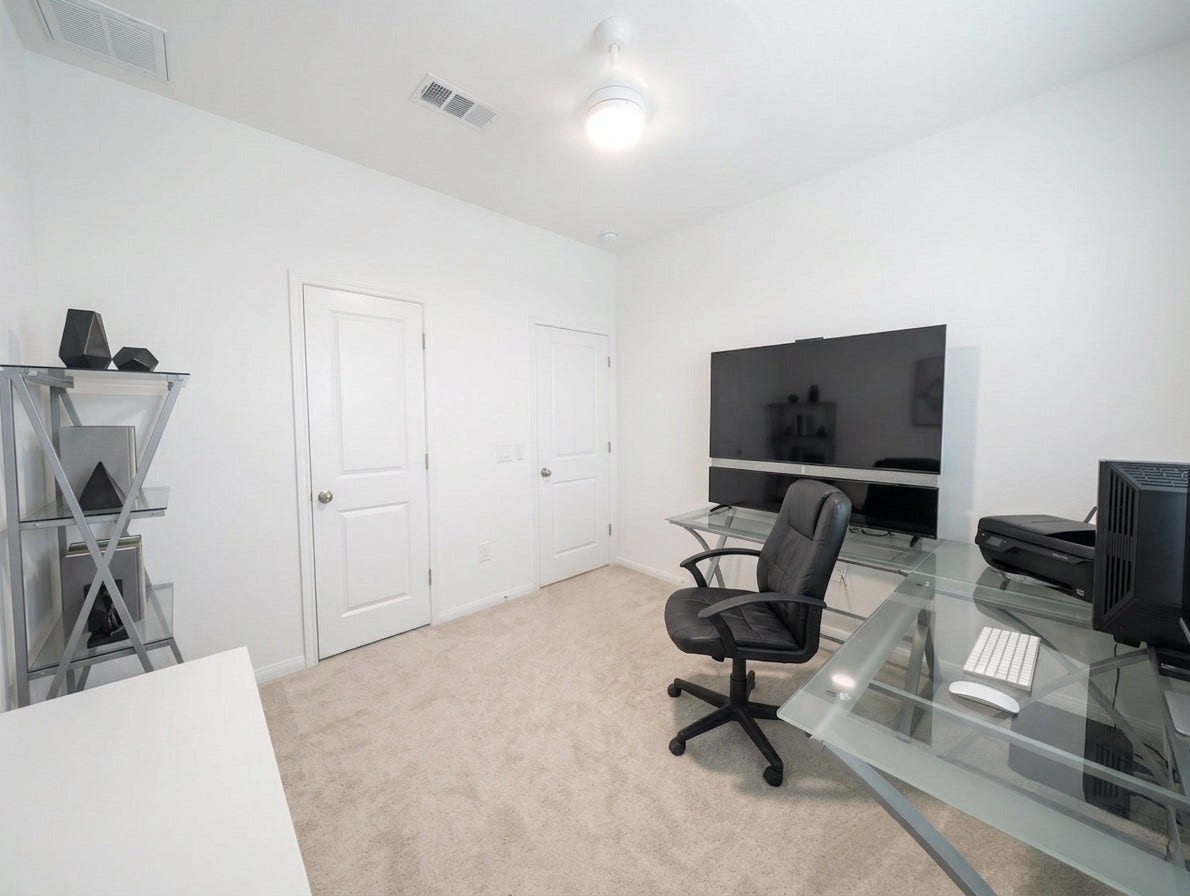 18122 Sonresa Way, Tomball, TX 77377 Bright study or flex room showcasing large windows, a desk workspace, and neutral tones.
