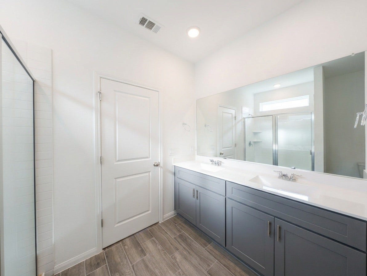 18122 Sonresa Way, Tomball, TX 77377 Luxurious primary ensuite bathroom featuring a dual-sink vanity with modern cabinetry, framed mirror, and a step-in shower.
