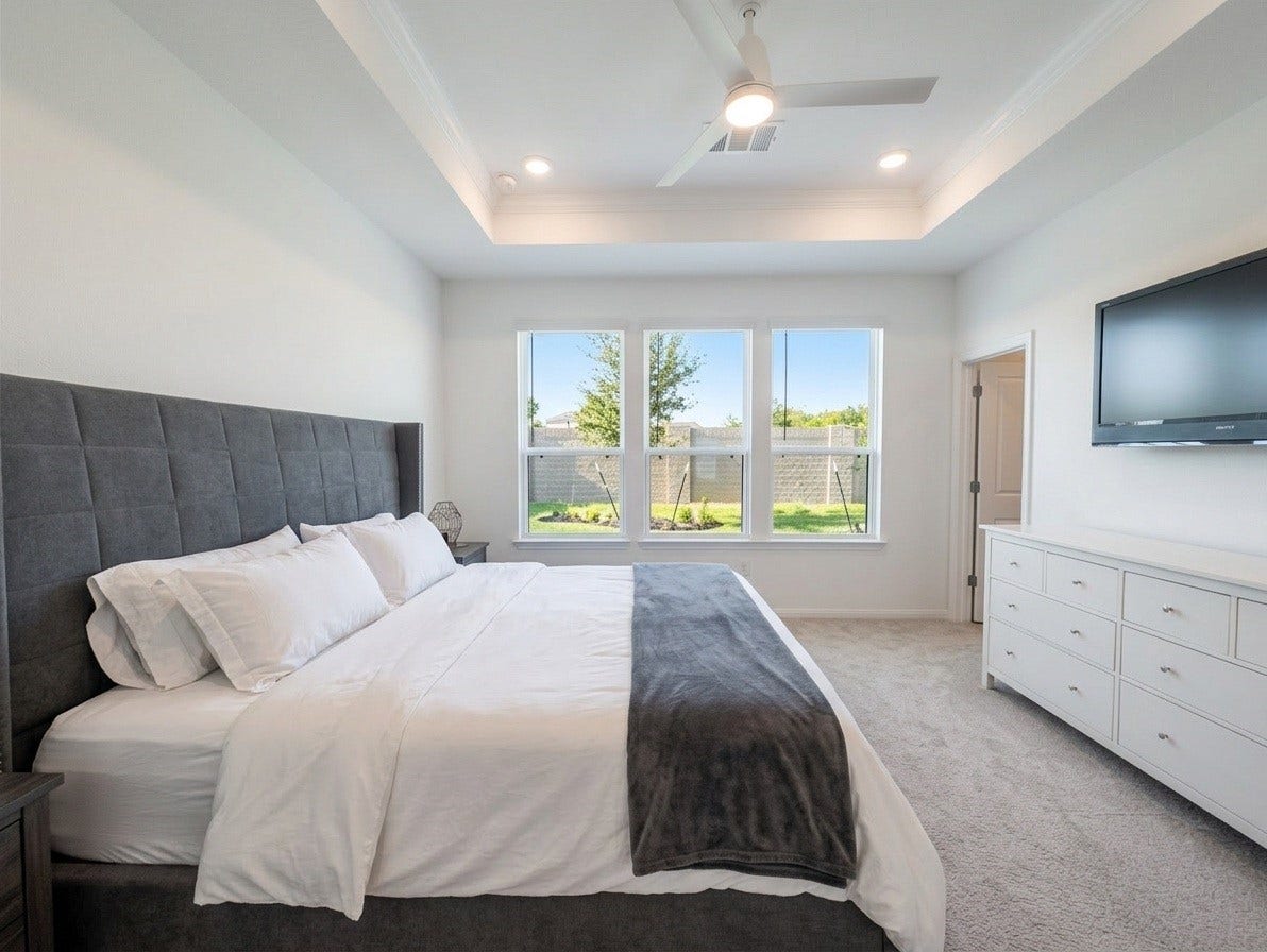 18122 Sonresa Way, Tomball, TX 77377 Expansive primary bedroom suite featuring plush carpeting, a tray ceiling, ceiling fan, and large windows bringing in natural light.