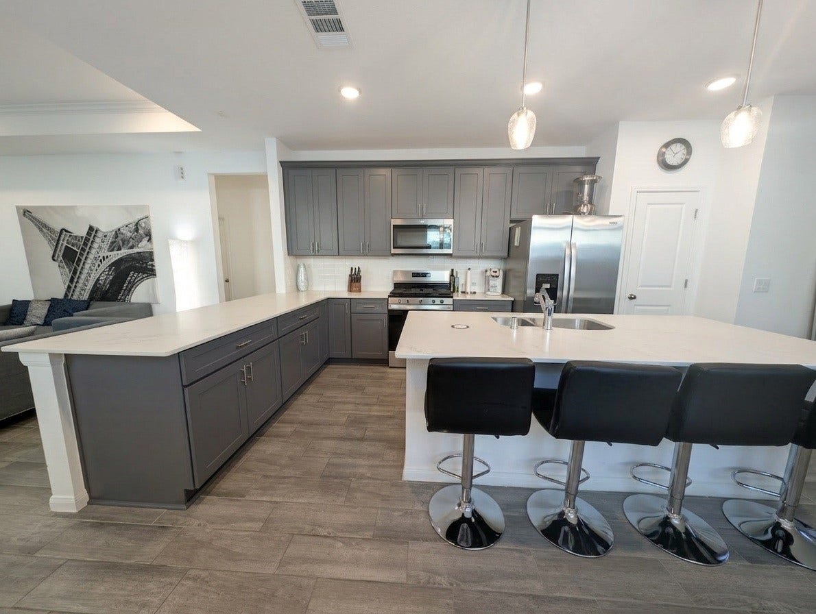 18122 Sonresa Way, Tomball, TX 77377 Alternate angle of the modern kitchen highlighting bar seating and extensive prep space.