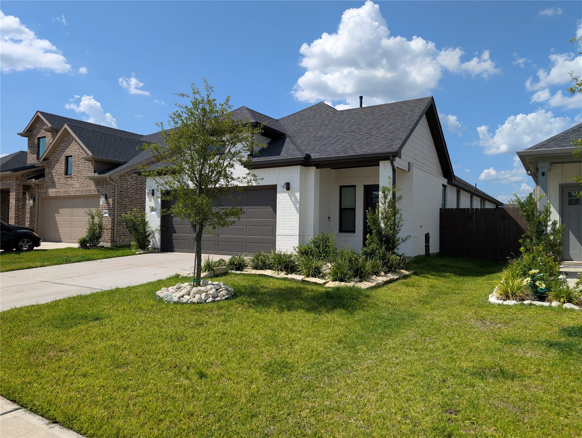 18122 Sonresa Way, Tomball, TX 77377 Wide-angle front view highlighting the expansive front yard landscaping, roof architecture, and property frontage.