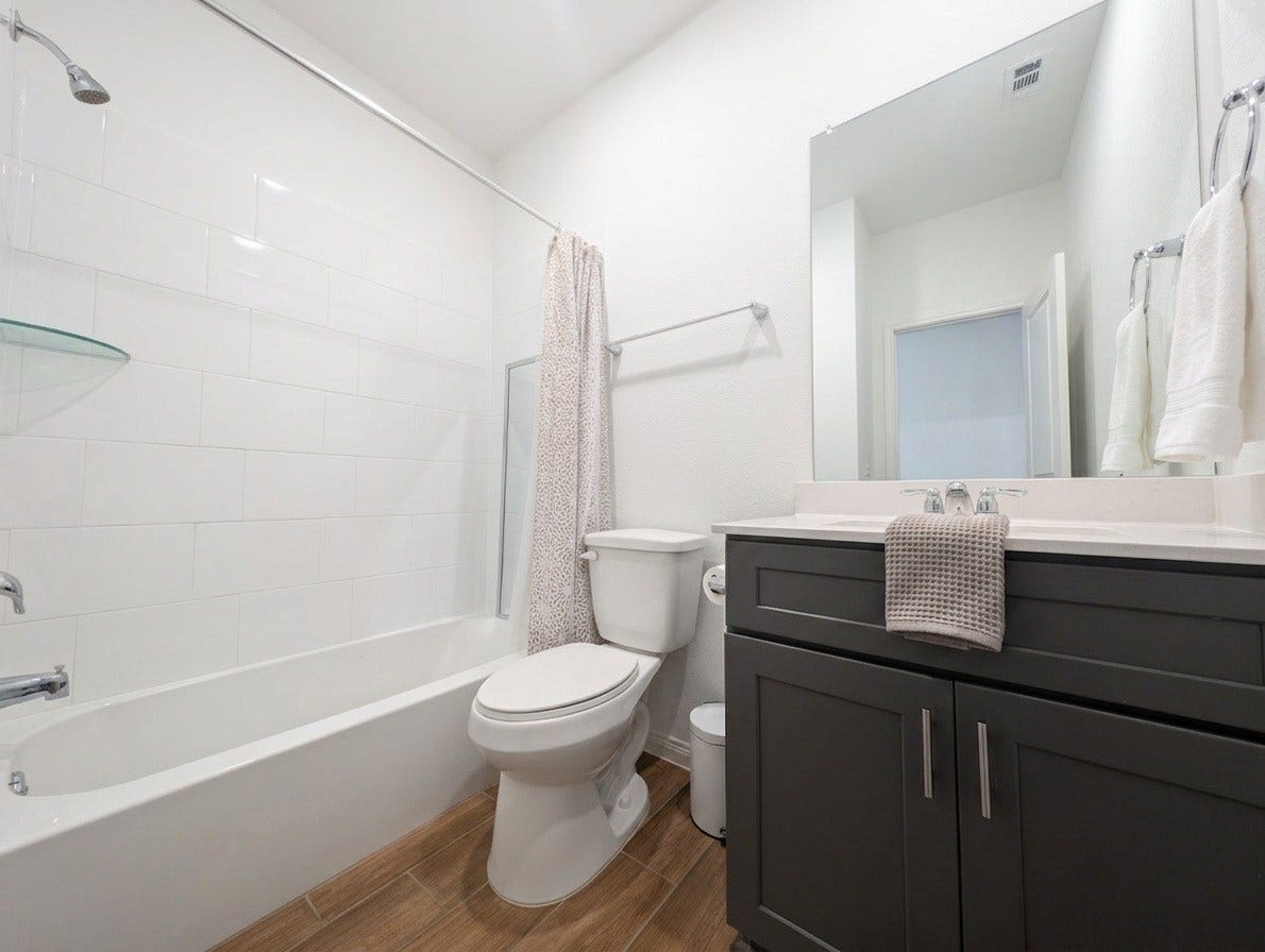 18122 Sonresa Way, Tomball, TX 77377 Well-appointed secondary bathroom featuring a modern vanity, framed mirror, and a combination tub-and-shower enclosure.