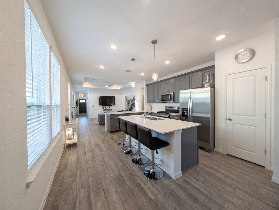 18122 Sonresa Way, Tomball, TX 77377 Kitchen workspace view displaying the sleek countertops, cabinetry, and open sightlines to the main living areas.
