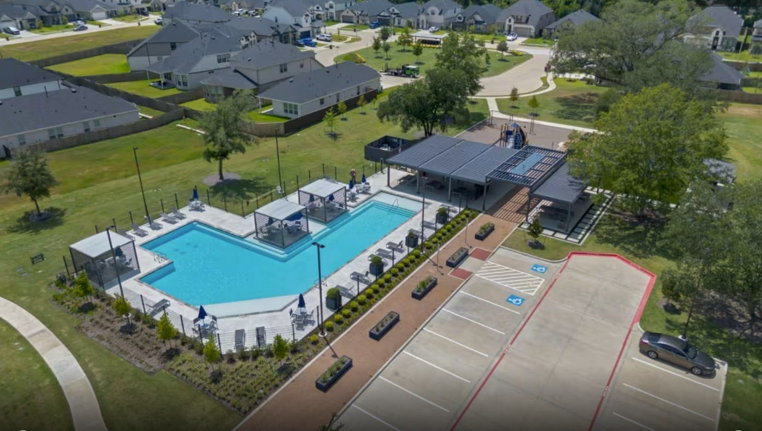 18122 Sonresa Way, Tomball, TX 77377 Aerial drone view of the community amenity center, featuring the neighborhood pool and surrounding layout.